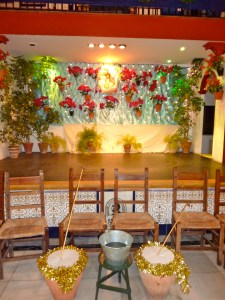 Zambombas ready for the fiesta at Central Cultural Antonio Chacon 2012. In between the two instruments is a bucket of water to wet down the leather at the top of the jug. Notice that the chairs are set in front of the stage, as a Zambomba is meant for audience participation